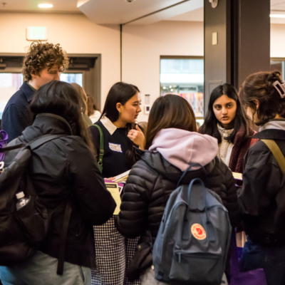 A group of people stand in a circle near a set of doors.