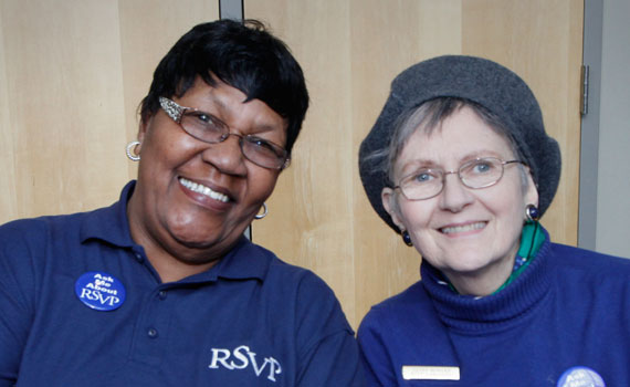 Two 55+ RSVP volunteers wearing navy blue shirts