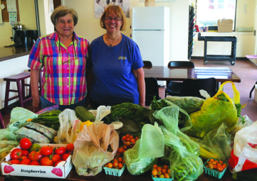 MCG gardeners Marty DeLong (l) and Kathy Dugaw (r) drop off a smorgasbord of veggies for residents of Solid Ground’s Sand Point Housing campus (photo by Christina Shimizu).