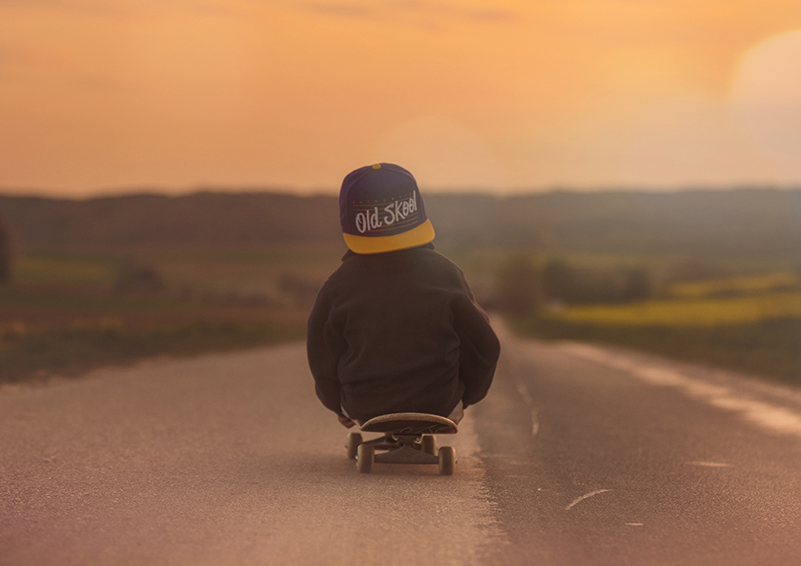 Boy sits on skateboard