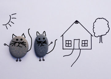 Line drawing of house with two cats made of rocks