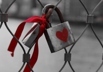 Lock with heart on a chainlink fence.