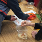 Students share bags of cut jicama to make takis together, using various spices.