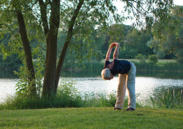Senior stretching by lake