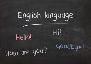 Blackboard with the words: English language, Hello! Hi! How are you? Goodbye?