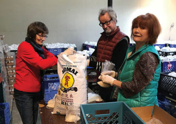RSVP volunteers Sarah Parkhurst, David Thornbrugh, and Charla Sullivan bagging rice for the Backpack Brigade