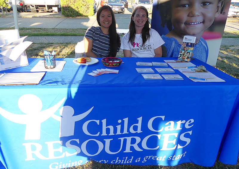 Two women smile at Child Care Resources table