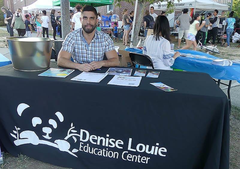 Man sits at Denise Louie Education Center's table.
