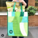 Person walking with a Whole Foods Market shopping bag