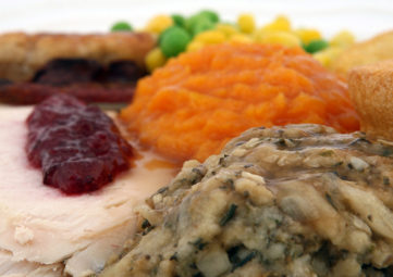 Thanksgiving foods: turkey with cranberry dressing, stuffing, squash, corn, & peas