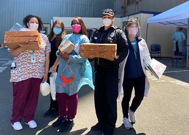 Five healthcare workers with donated food boxes