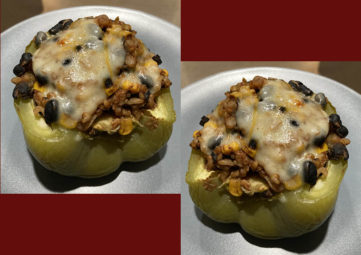 Two stuffed green bell peppers topped with melted cheese on a brick red background
