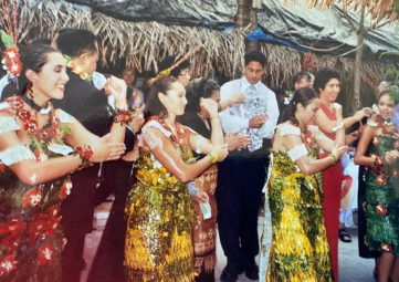 Group of Tongan women in colorful dresses dancing at a wedding