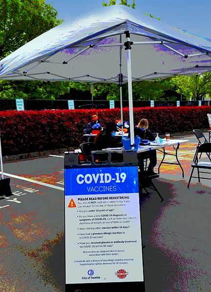 Tent in parking lot with sign in front advertising vaccine clinic