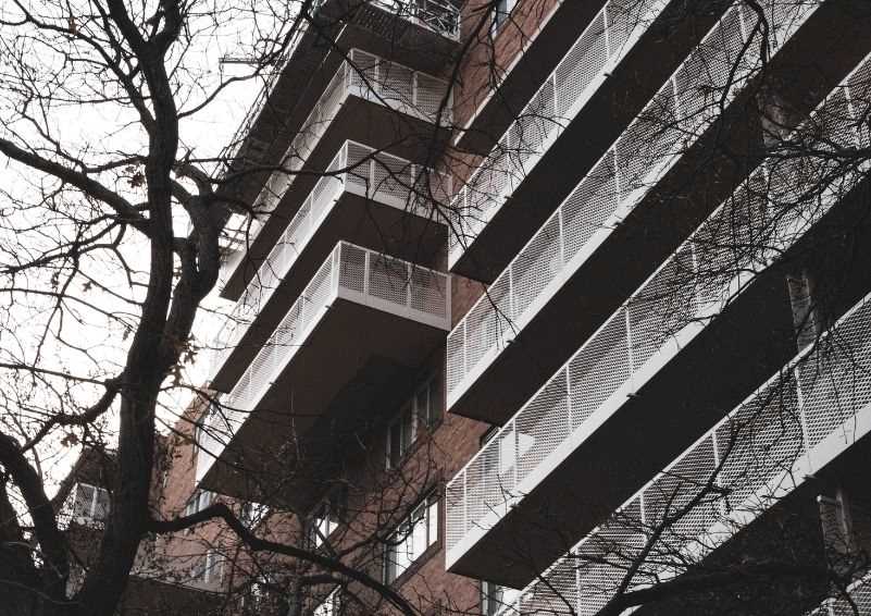 Exterior shot of a brick apartment building with several decks.