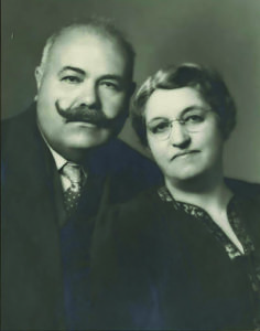 Black and white photo of a middle aged man with a handlebar mustache and his wife, circa 1930s