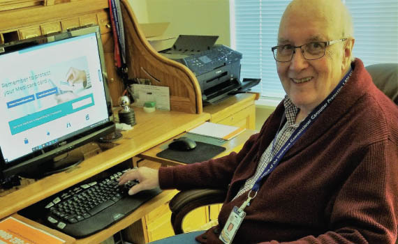 Senior man at a computer with Medicare info on his screen