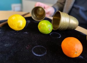 Several pieces of fruit and brass cups on a table