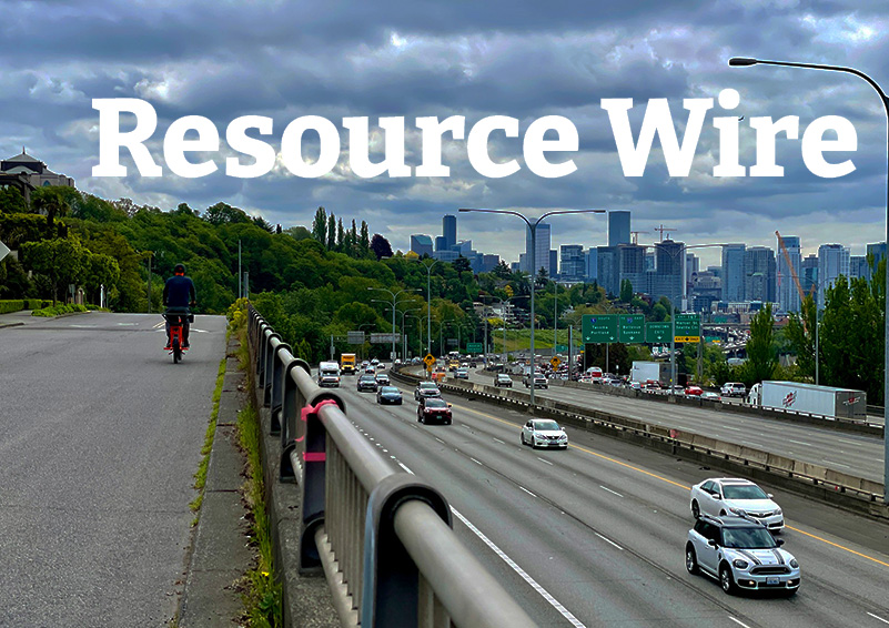 A view of the downtown Seattle skyline and I-5 with the words "Resource Wire" embossed over the clouds above the city