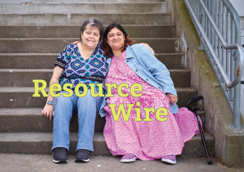 Two women, one wearing a jeans jacket over a flowing ping dress and the other wearing a blue blouse and jeans, sit shoulder to shoulder on on a concrete stairway. The words "Resource Wire" appear on the image.