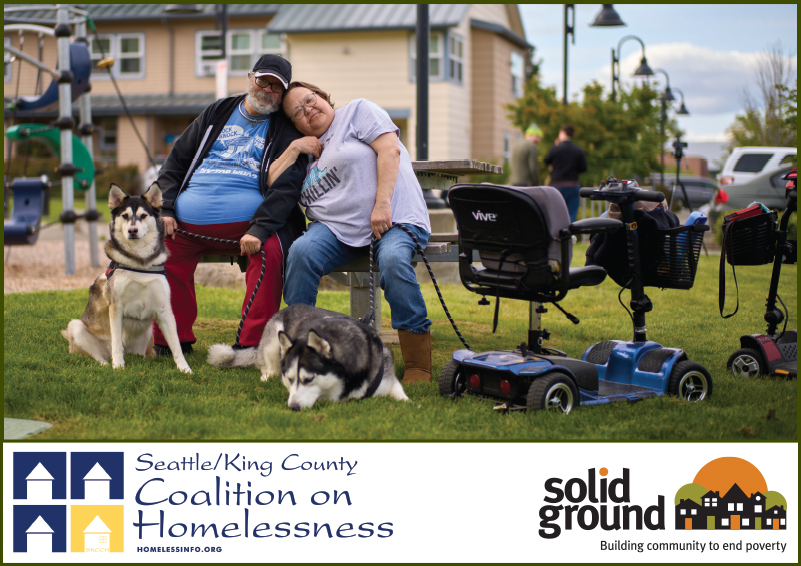 A man and woman cuddle on a playground bench with their two huskies and two motorized wheelchairs nearby. Seattle/ King County Coalition on Homelessness and Solid Ground logos at the bottom.
