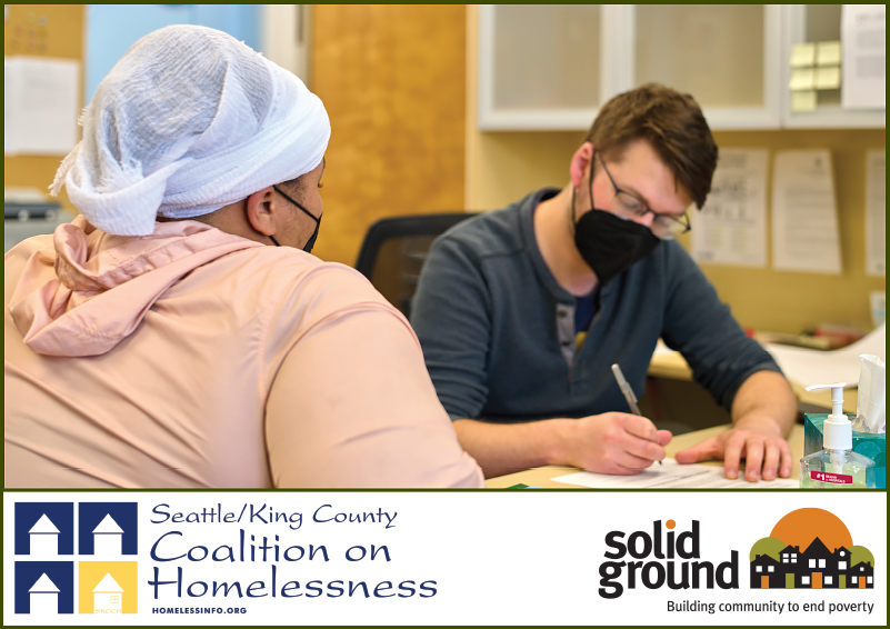 A man and woman wearing facemasks fill out paperwork at a desk. Seattle/ King County Coalition on Homelessness and Solid Ground logos at the bottom.