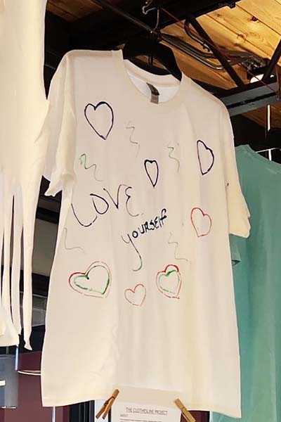 White T-shirt with the text LOVE yourself, with hearts drawn around it.