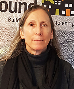 Portrait of a white woman with brown hair wearing a black turtleneck and scarf