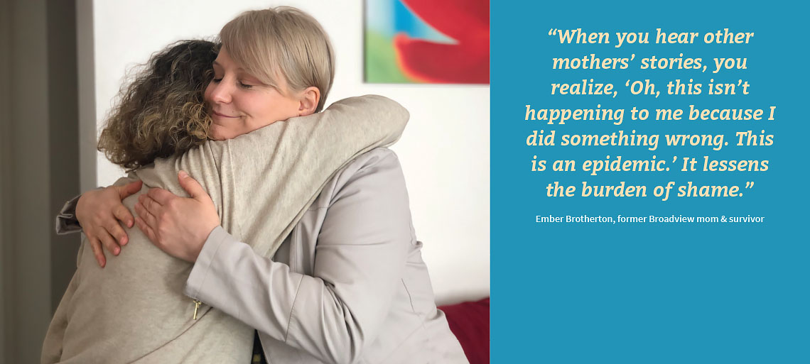 Two women hugging on the left side. On the right is light orange text on a bright blue background reading: “When you hear other mothers’ stories, you realize, ‘Oh, this isn’t happening to me because I did something wrong. This is an epidemic.’ It lessens the burden of shame.” Ember Brotherton, former Broadview mom & survivor