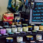 A display of cremes and other hand-crafted beauty products besides a chalk board described the products, including beard oil and lip balm.