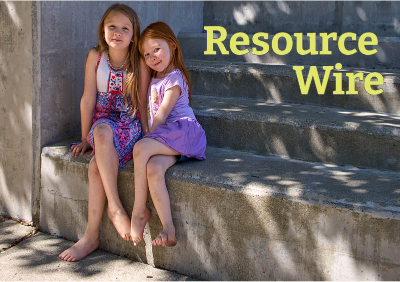 Two young sisters sit by side by side on a concrete staircase, their legs crossed. The words Resource Wire appear beside them.