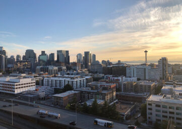 A view of the downtown Seattle Skyline with I-5 in the foreground and the Space Needle in the distance.