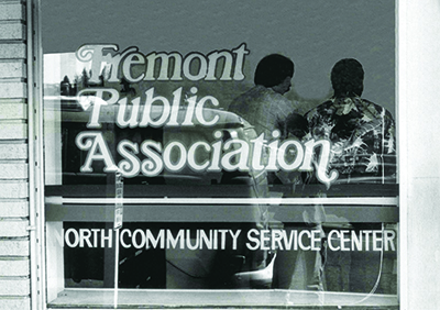 A black-and-white photos of a storefront window that reads "Fremont Public Association, North Community Service Center."