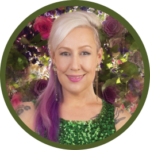 Circular photo with a forest-green frame of a white woman with long, white and pinkj-purple hair and shoulder tattoos wearing a green sequined sleeveless dress, in front of a floral background.