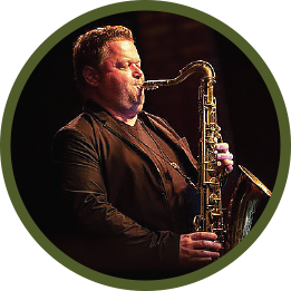 Circular photo with a forest-green frame of a white man with light-brown hair wearing all black, and playing a saxophone with his eyes shut.