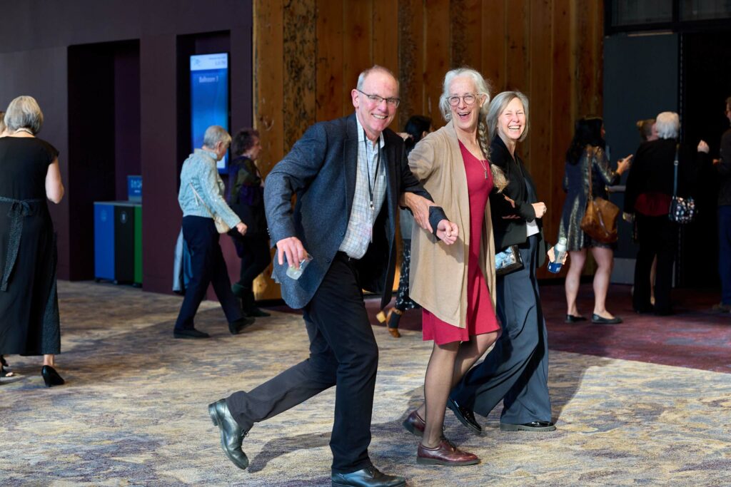 A group of people pause mid stride to smile at the camera.