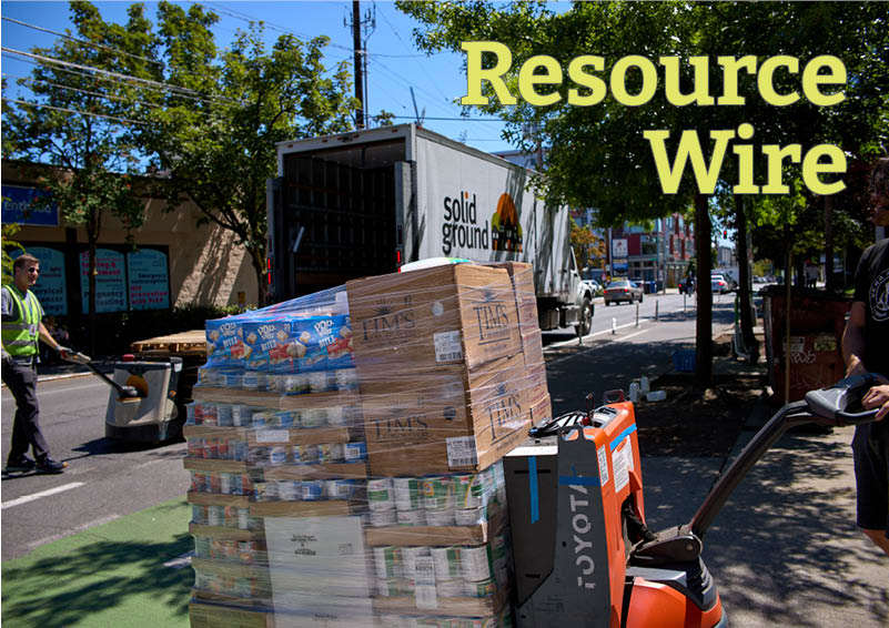 A pallet of packaged food sits in front of a large truck that says "Solid Ground" on the side. The words "Resource Wire" appear at the top of the image.