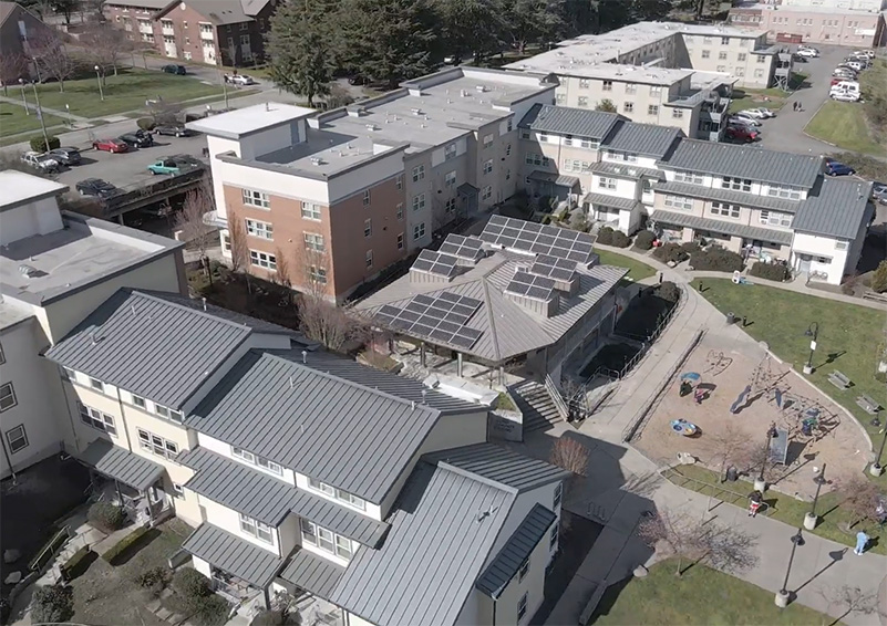 An aerial view of several apartment buildings arranged around a playground.