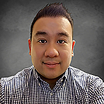 Headshot of a an Asian person with short black hair wearing a black and white checkered shirt, in front of a grey background.