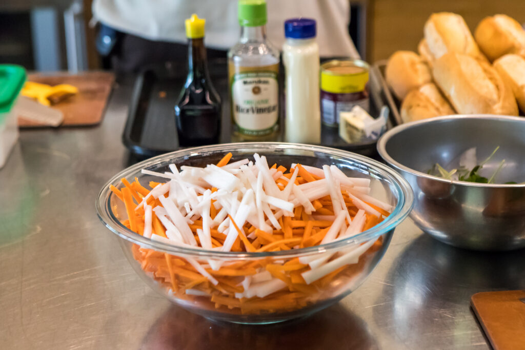 A bowl of julienned carrots and daikon radishes.