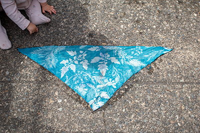 A blue-dyed bandana with white imprints of flowers and leaves.