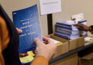 A man holds a booklet about mold.