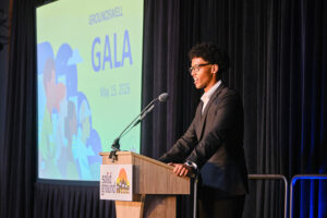 A young man in a suit at a podium