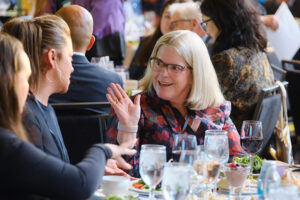 A woman sitting at a table gesturing at her hands while talking