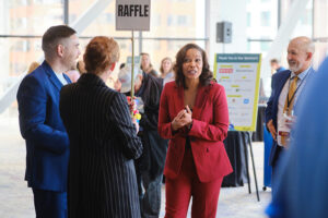 A women in red suit talking to a small group of people
