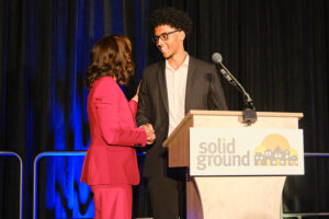 Two people behind a podium that says Solid Gruond