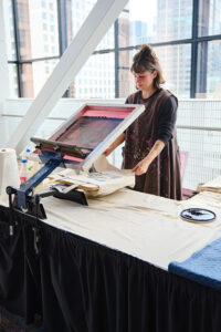 A women operating a screen printing machine