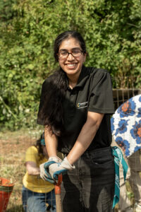 A volunteer leaning on a shovel at the farm.