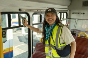 A volunteer in a reflective vest inside a paratransit vehicle.