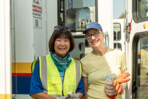 Two people infront of paratransit vehicles.